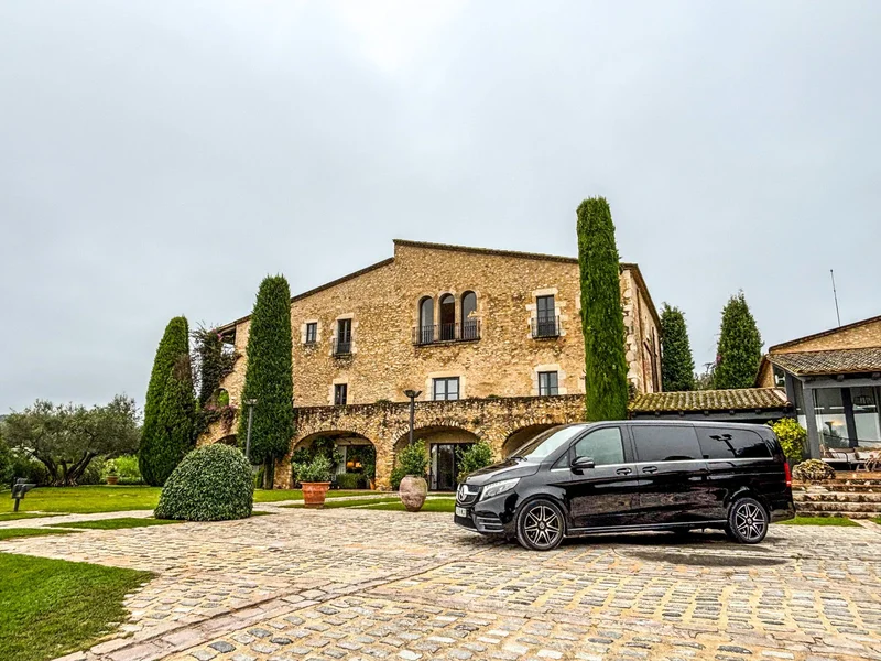 Mercedes Benz V Class negra estacionada frente a la fachada de piedra de Mas de Torrent Hotel & Spa