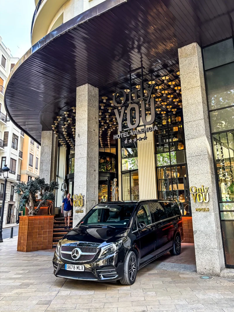 Mercedes-Benz V-Class negra de BlackButton estacionada frente a la entrada del Only YOU Hotel Valencia