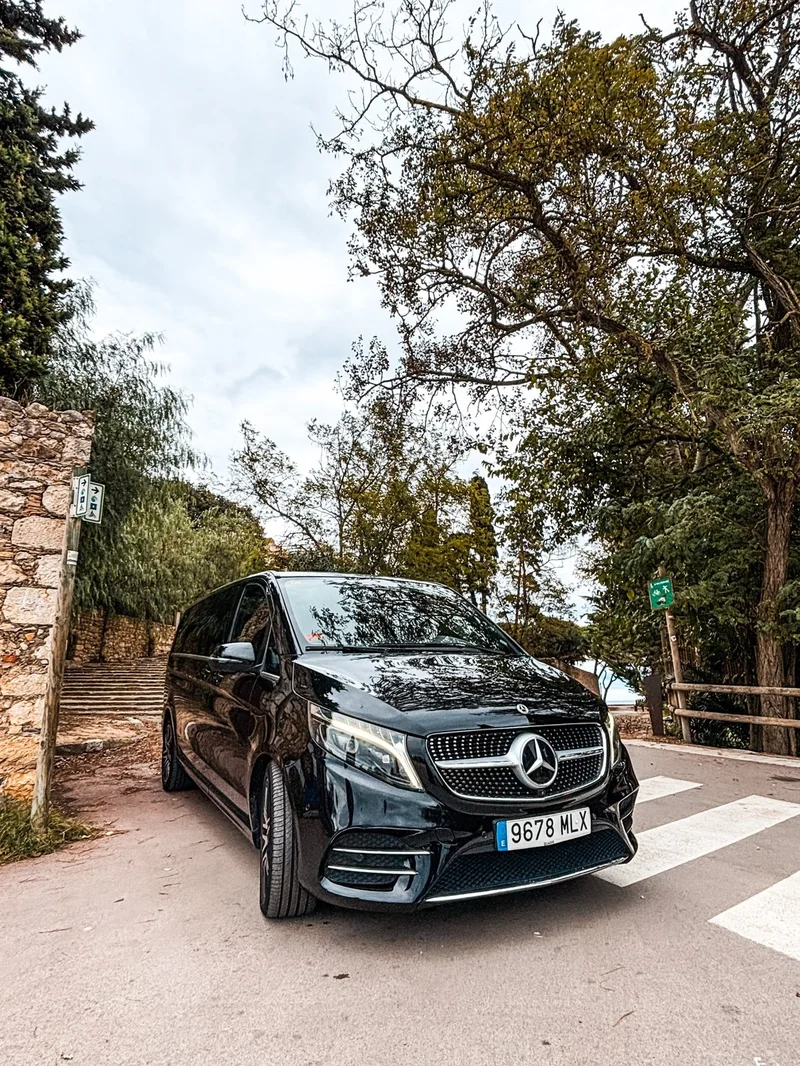 Mercedes-Benz V-Class negra de Black Button estacionada junto a un muro de piedra en Sant Martí d'Empúries, Costa Brava